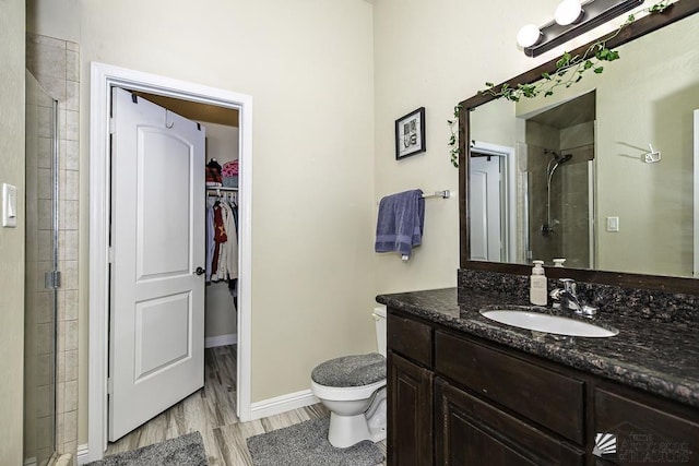 bathroom with vanity, hardwood / wood-style floors, an enclosed shower, and toilet