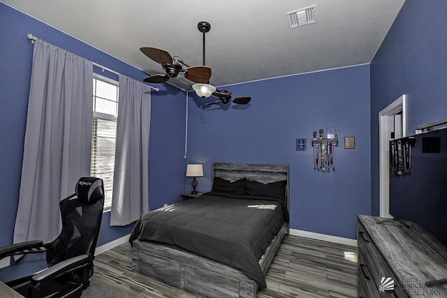 bedroom with ceiling fan and dark hardwood / wood-style flooring