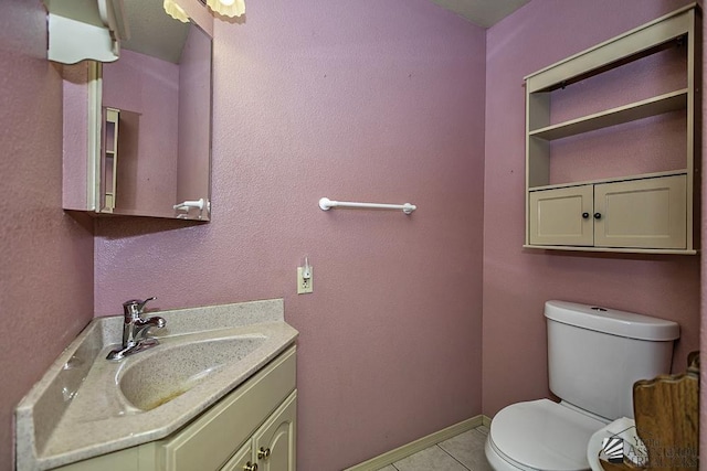 bathroom with tile patterned flooring, vanity, and toilet