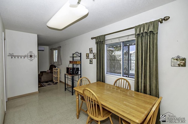 dining area featuring a textured ceiling and a wall mounted AC