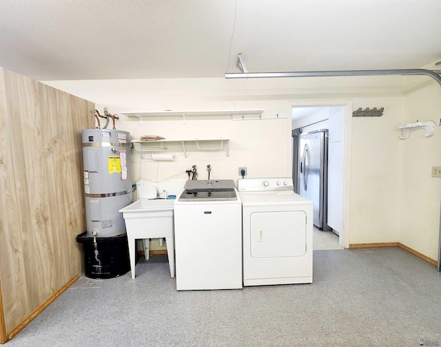 laundry room with secured water heater, wood walls, and independent washer and dryer