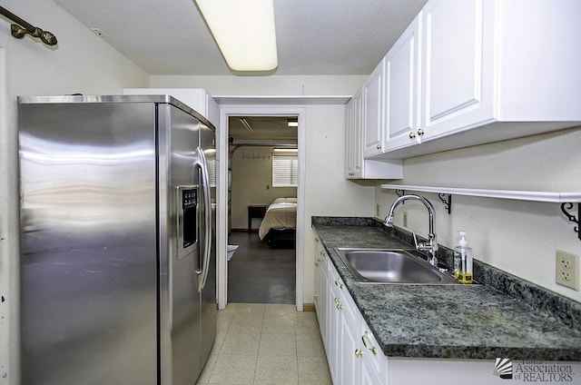 kitchen with white cabinets, stainless steel refrigerator with ice dispenser, and sink