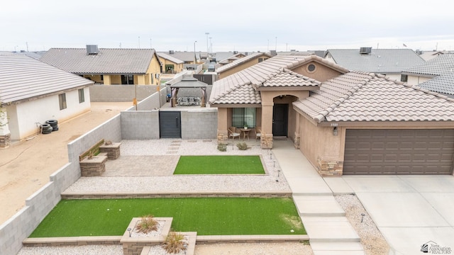 view of front facade featuring a garage and a gazebo