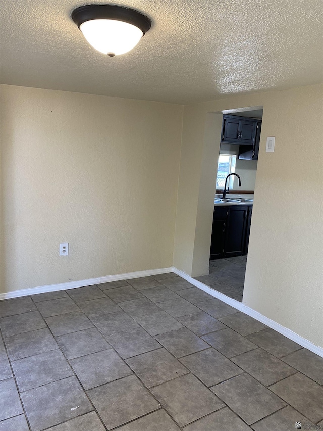 empty room featuring sink and a textured ceiling