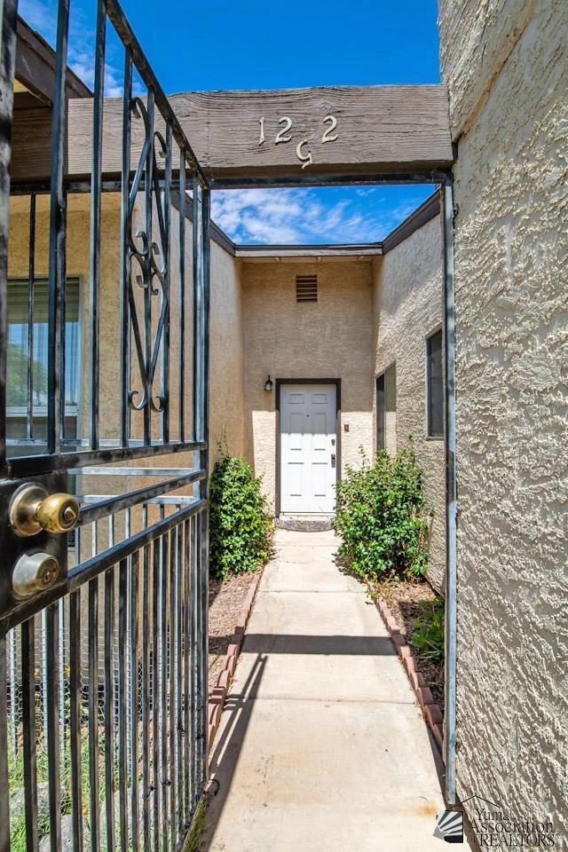 entrance to property with a gate and stucco siding