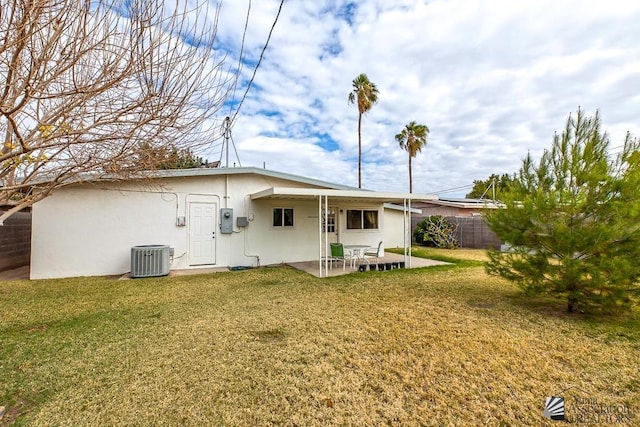 rear view of house featuring a patio, a yard, and central AC