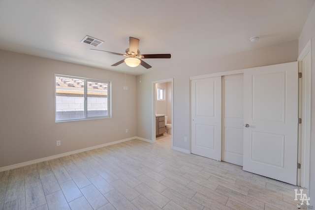 unfurnished bedroom featuring ceiling fan, a closet, and ensuite bath