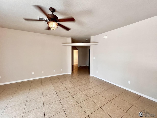 spare room featuring a textured ceiling, ceiling fan, and light tile patterned flooring