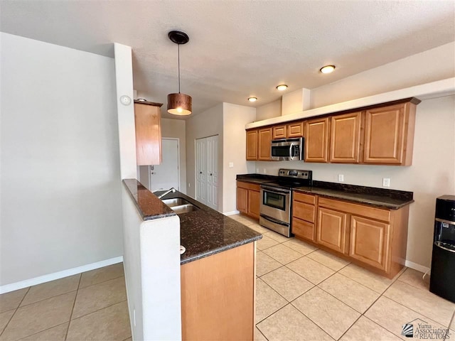 kitchen featuring sink, light tile patterned floors, pendant lighting, and appliances with stainless steel finishes