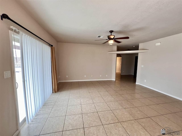 unfurnished room with ceiling fan, light tile patterned floors, and a textured ceiling