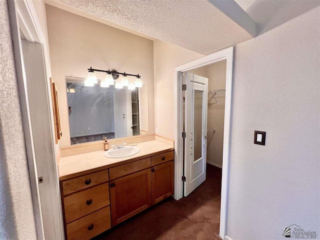 bathroom with vanity and a textured ceiling