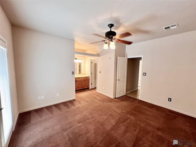 unfurnished bedroom with carpet flooring, ceiling fan, and ensuite bathroom