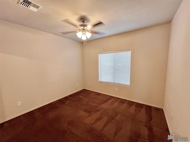 carpeted spare room with ceiling fan and a textured ceiling