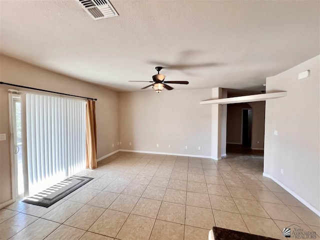 tiled spare room featuring ceiling fan