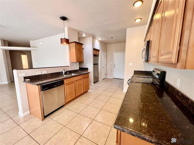 kitchen featuring decorative light fixtures, dark stone countertops, light tile patterned floors, and stainless steel appliances