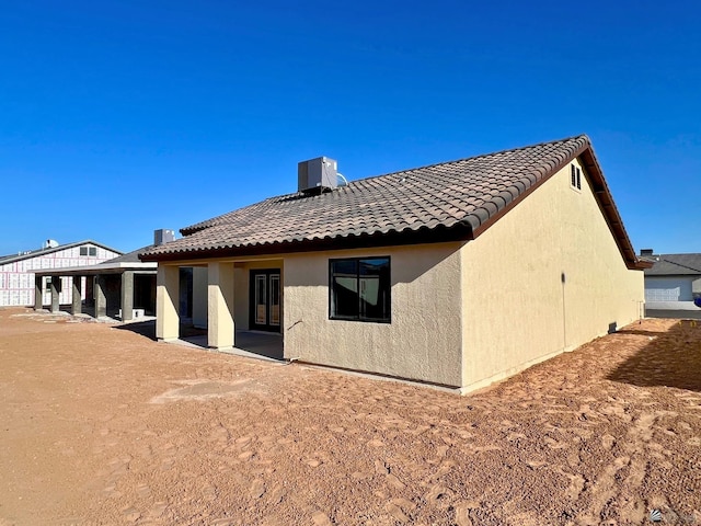 rear view of property featuring a patio and central air condition unit