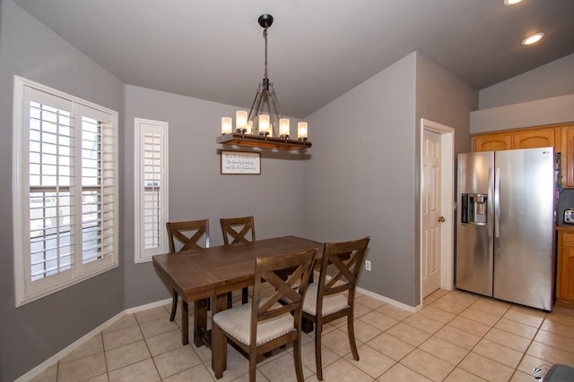 dining room featuring a chandelier, light tile patterned flooring, vaulted ceiling, and baseboards