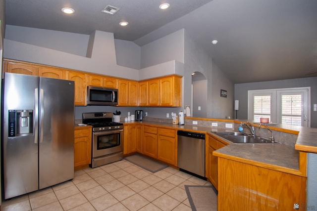 kitchen with visible vents, lofted ceiling, appliances with stainless steel finishes, a peninsula, and a sink