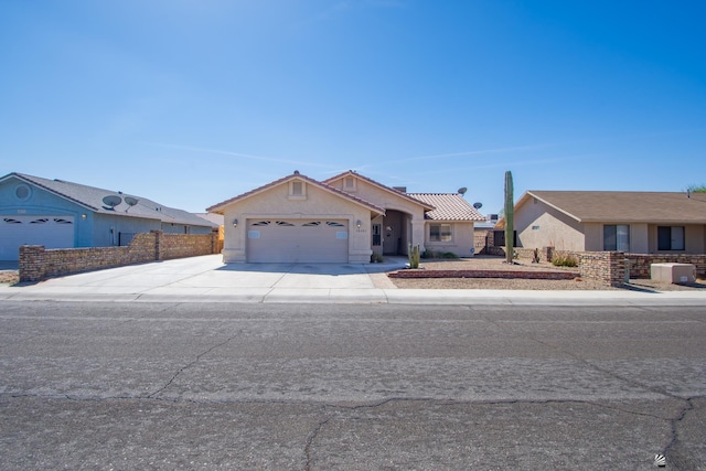 view of front of house with concrete driveway, an attached garage, fence, and stucco siding