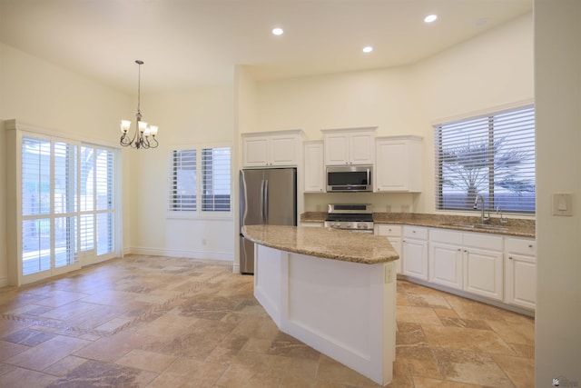 kitchen with white cabinetry, sink, a center island, an inviting chandelier, and appliances with stainless steel finishes