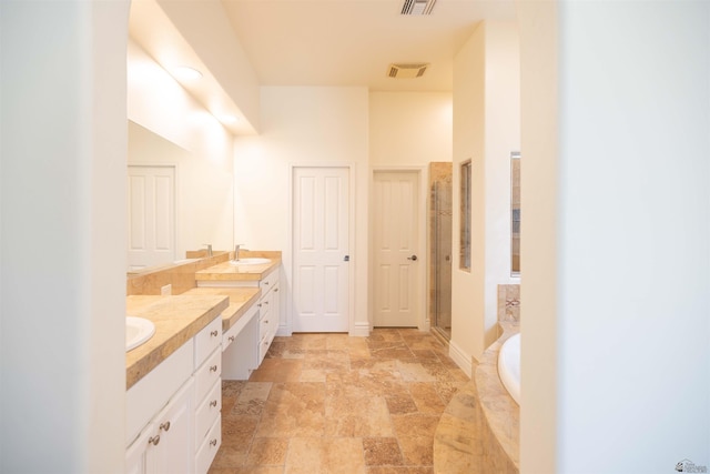 bathroom featuring vanity and independent shower and bath