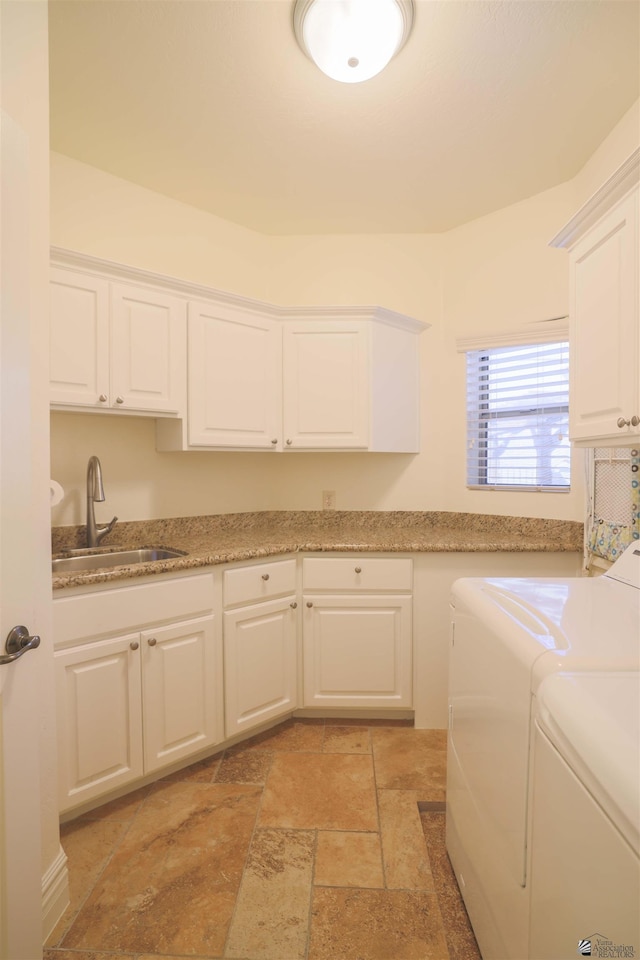 laundry room featuring washer and dryer, cabinets, and sink