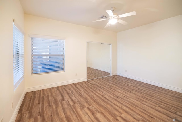 unfurnished bedroom featuring ceiling fan, a closet, and hardwood / wood-style flooring