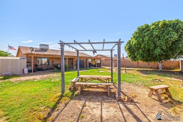 view of yard with a pergola, cooling unit, and a storage shed