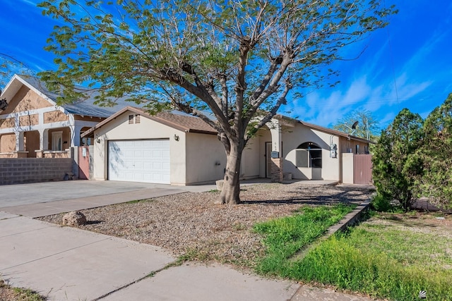 single story home featuring a garage, concrete driveway, fence, and stucco siding