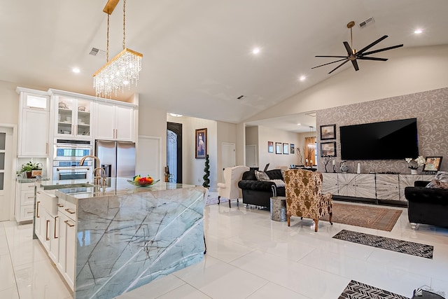 kitchen with white cabinetry, light stone counters, decorative light fixtures, stainless steel fridge with ice dispenser, and a large island