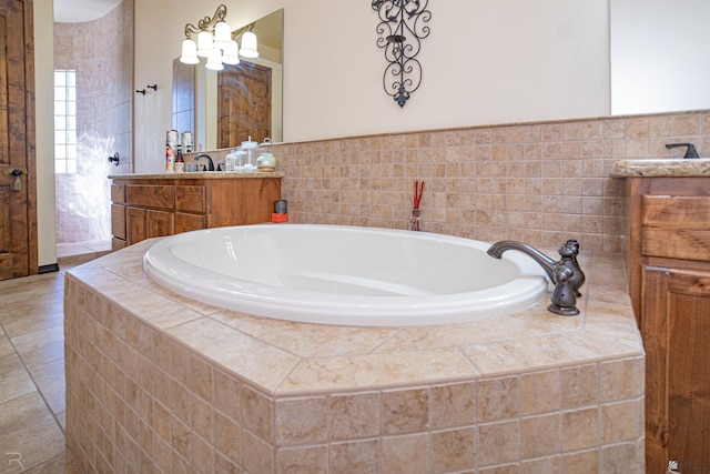 bathroom with tiled tub and vanity