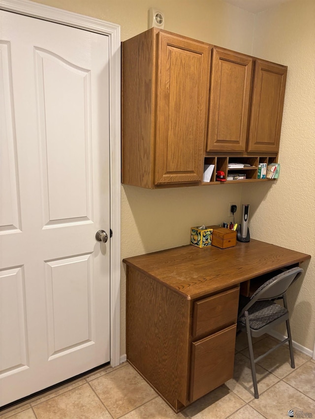 home office with light tile patterned flooring and baseboards