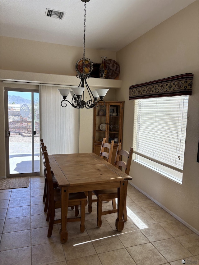 dining space featuring light tile patterned floors, visible vents, and baseboards