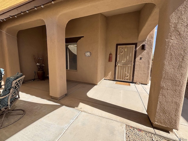 doorway to property with a patio area and stucco siding