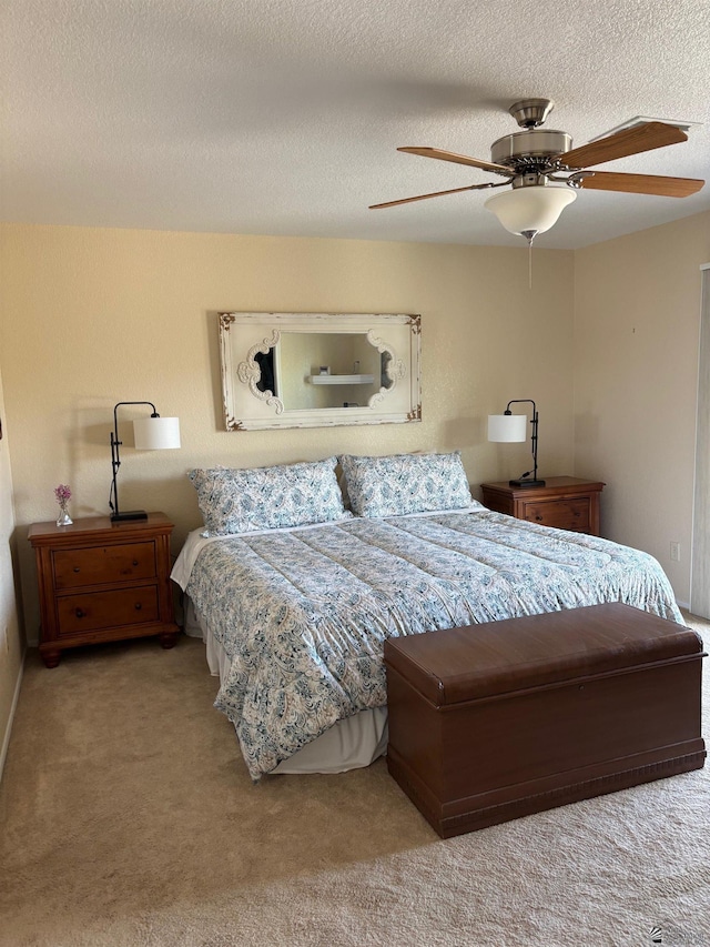 bedroom with a textured ceiling, ceiling fan, and carpet