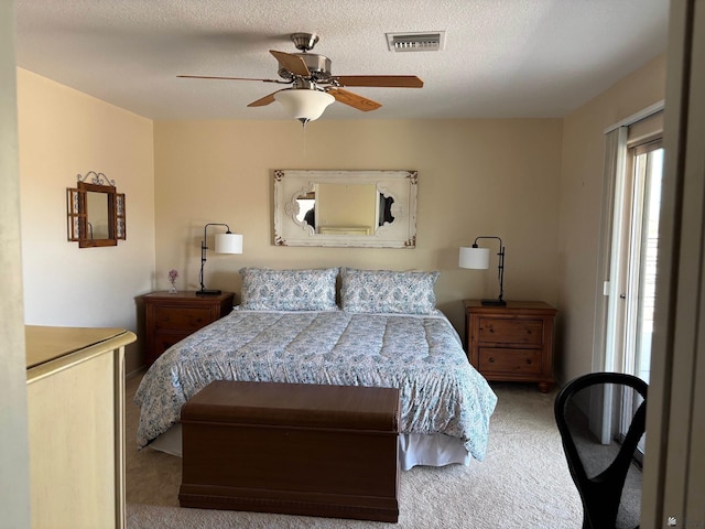 bedroom featuring carpet flooring, ceiling fan, visible vents, and a textured ceiling