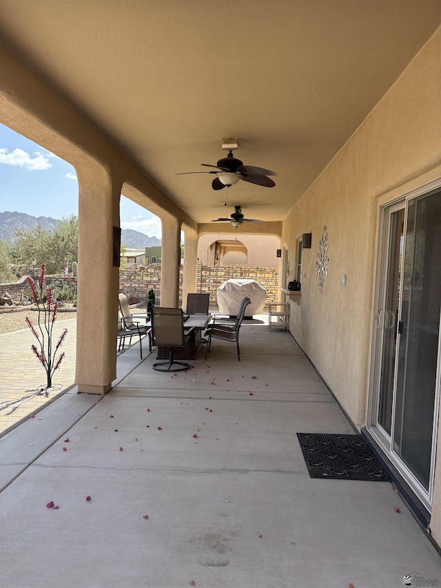 view of patio with ceiling fan and a mountain view