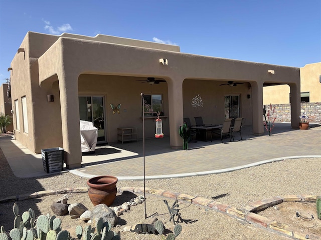 back of property with a patio, a ceiling fan, and stucco siding