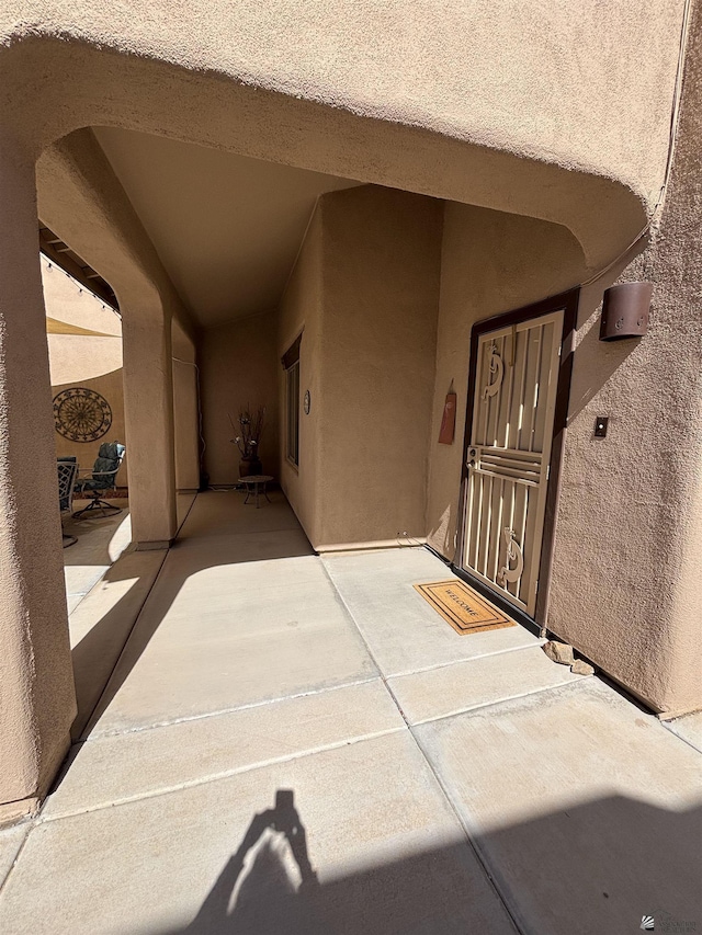 doorway to property with a patio and stucco siding