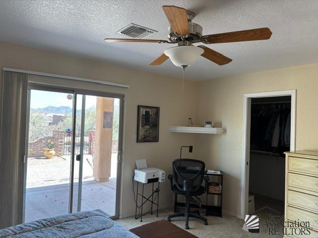 bedroom with a textured ceiling, ceiling fan, visible vents, access to outside, and carpet