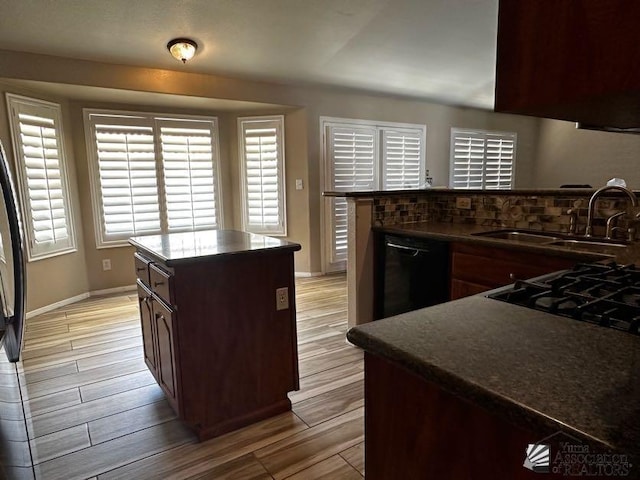 kitchen featuring sink, a kitchen island, dark brown cabinets, and black dishwasher