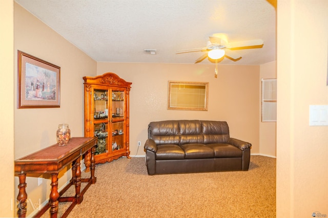 carpeted living room with ceiling fan and a textured ceiling