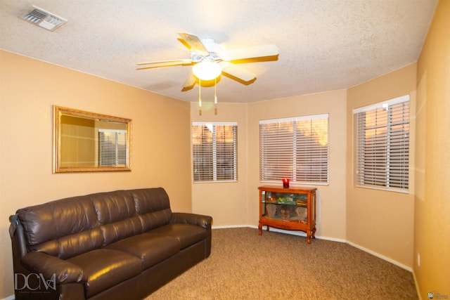 living room with a textured ceiling, carpet floors, and ceiling fan