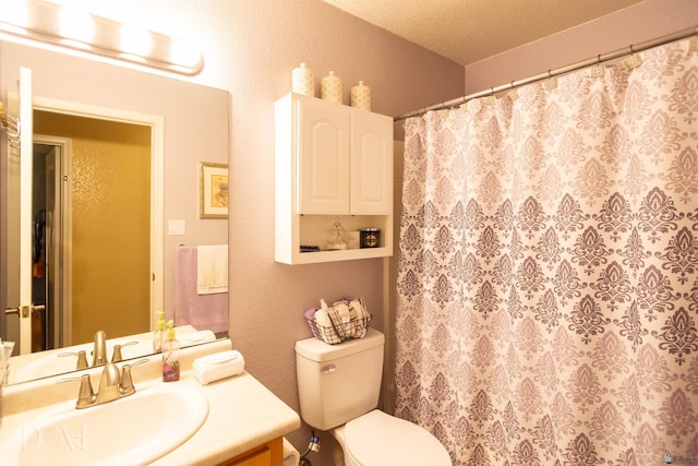 bathroom featuring a shower with curtain, vanity, a textured ceiling, and toilet