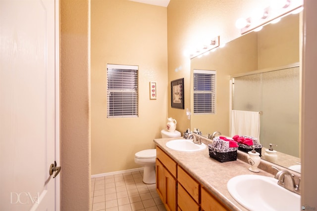 bathroom featuring tile patterned flooring, vanity, toilet, and walk in shower