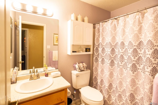 bathroom featuring vanity, toilet, and a textured ceiling