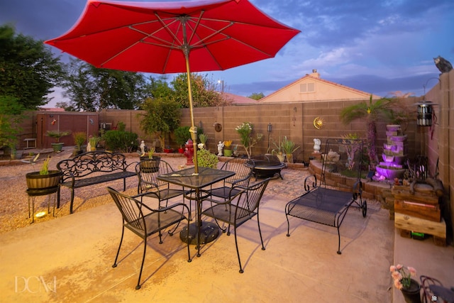 patio terrace at dusk featuring an outdoor fire pit