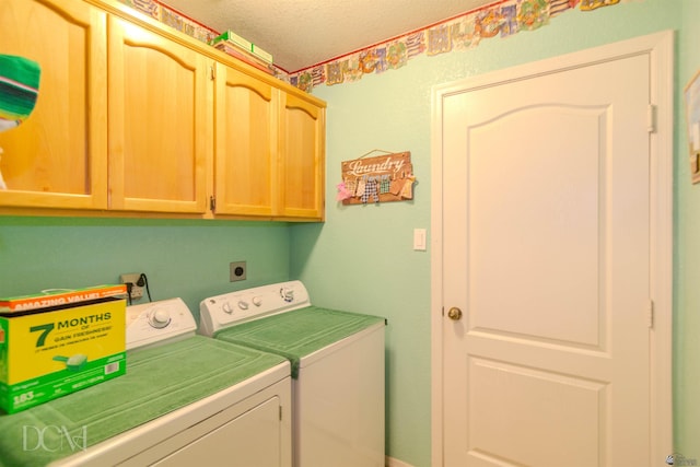 washroom with washer and clothes dryer, cabinets, and a textured ceiling