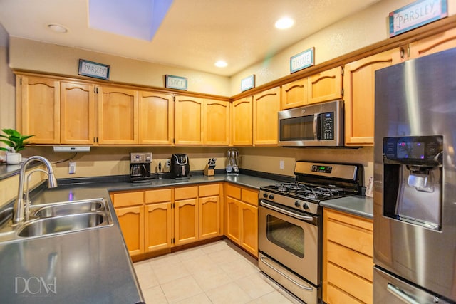 kitchen with light tile patterned floors, stainless steel appliances, and sink