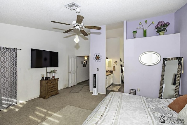 carpeted bedroom with ceiling fan, ensuite bathroom, a textured ceiling, and a high ceiling